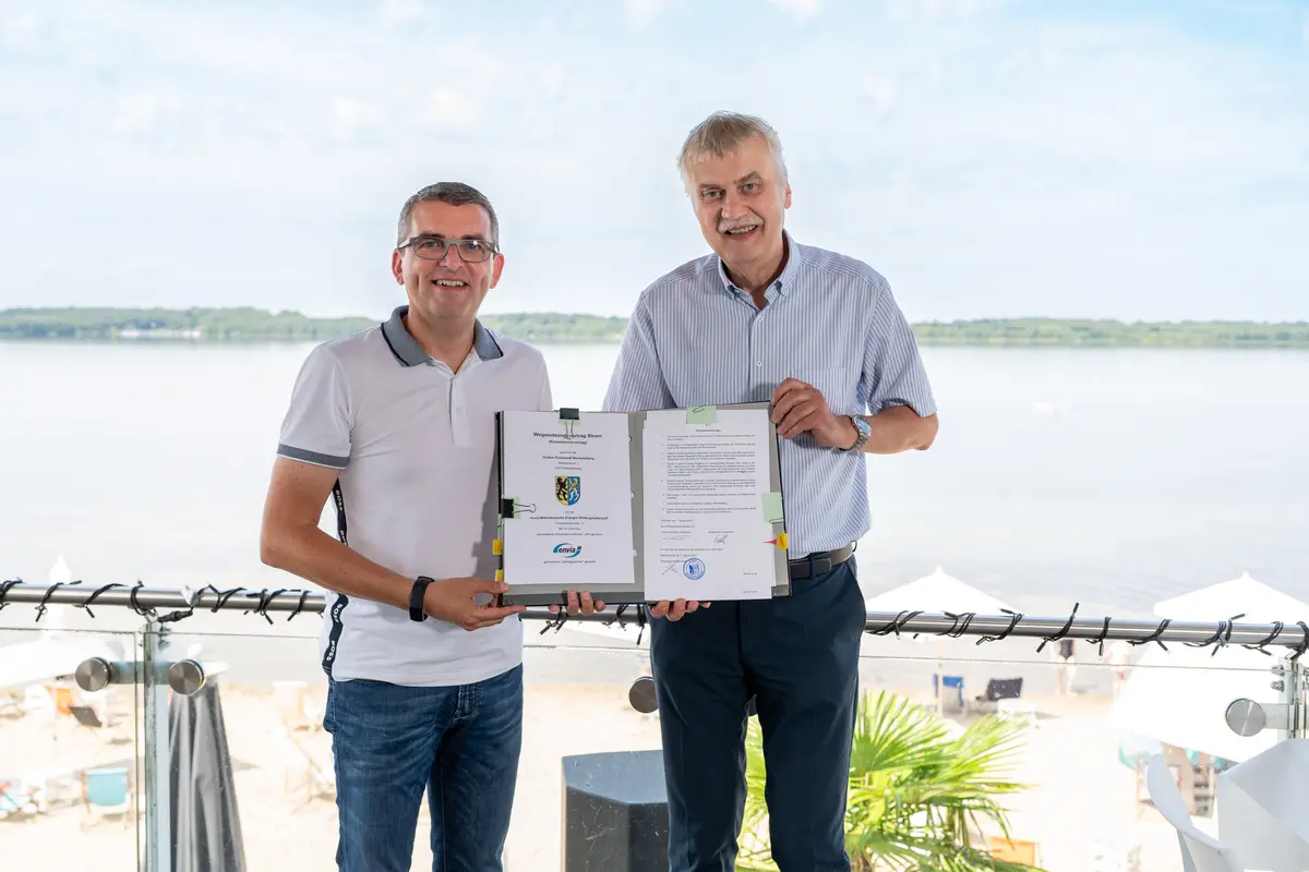 Zwei Männer zeigen den neuen, unterschriebenen Konzessionsvertrag.
