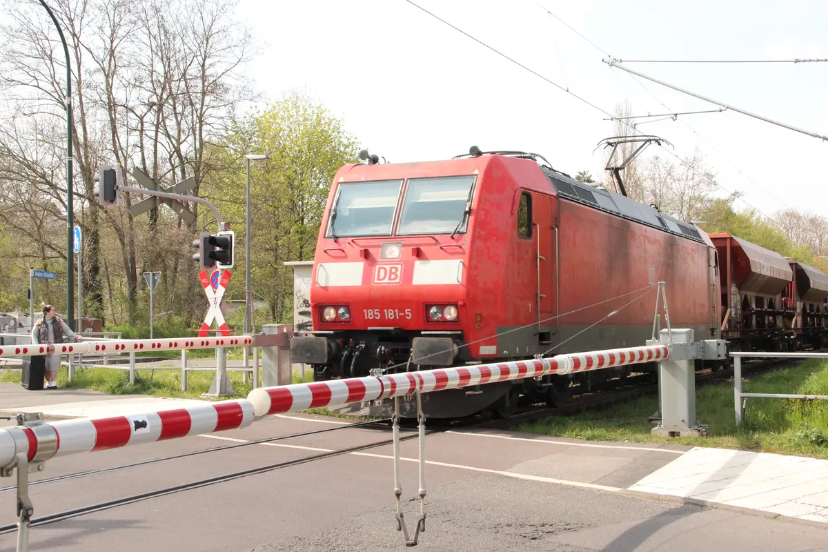 Eine Lok fährt an einem Bahnübergang vorüber.