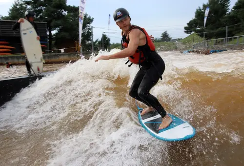 Ein Surfer auf einer stehenden Welle im Kanupark.