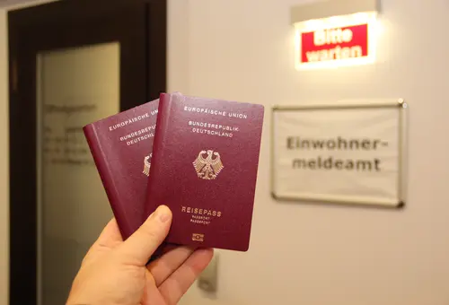 Eine Person zeigt zwei Reisepässe.
