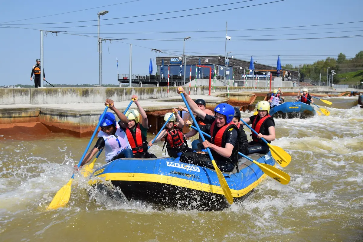 Ein Raftingteam fährt in einem Schlauchboot die Wildwasseranlage hinab.