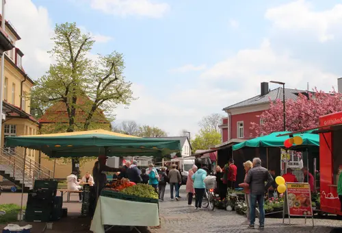 Buden und Menschen beim Wochen- und Genussmarkt.