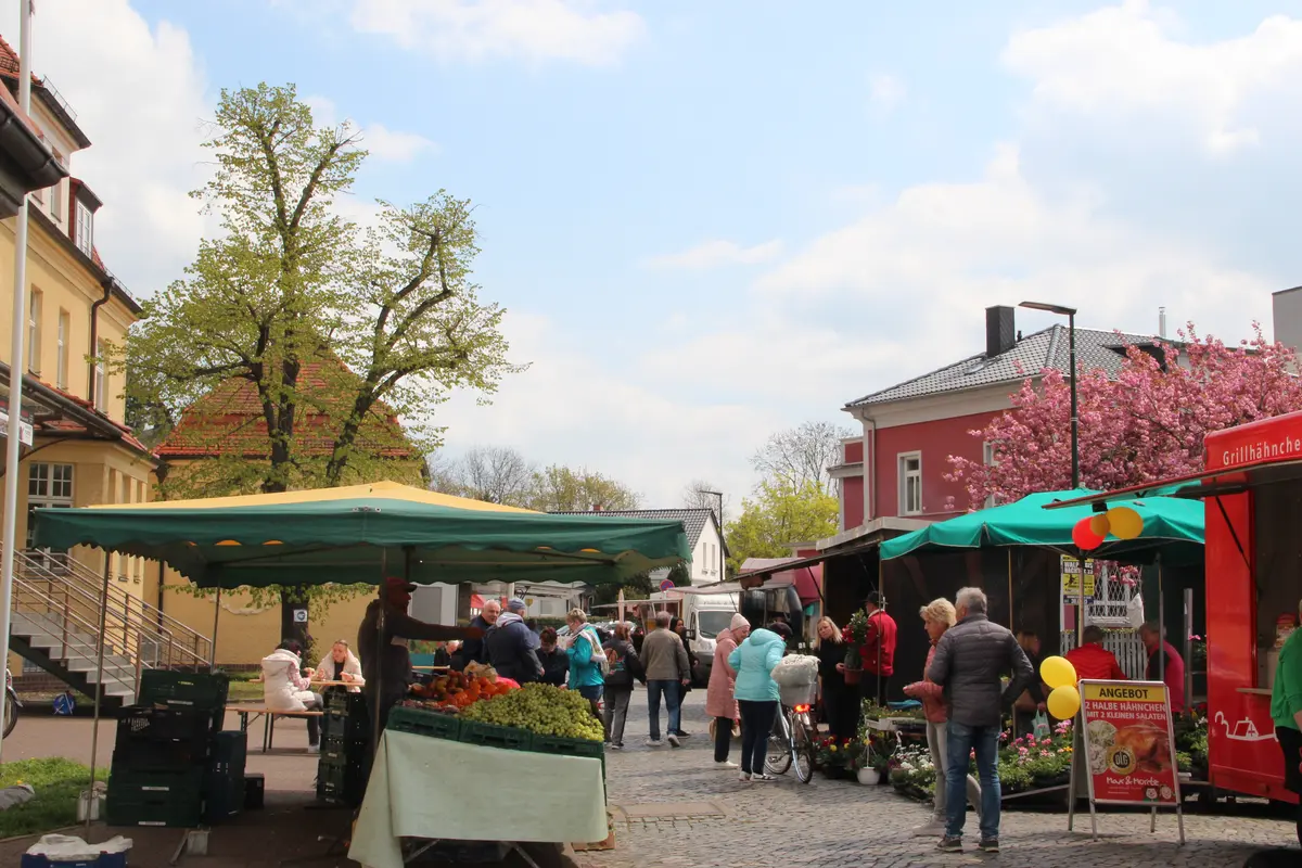 Buden und Menschen beim Wochen- und Genussmarkt.